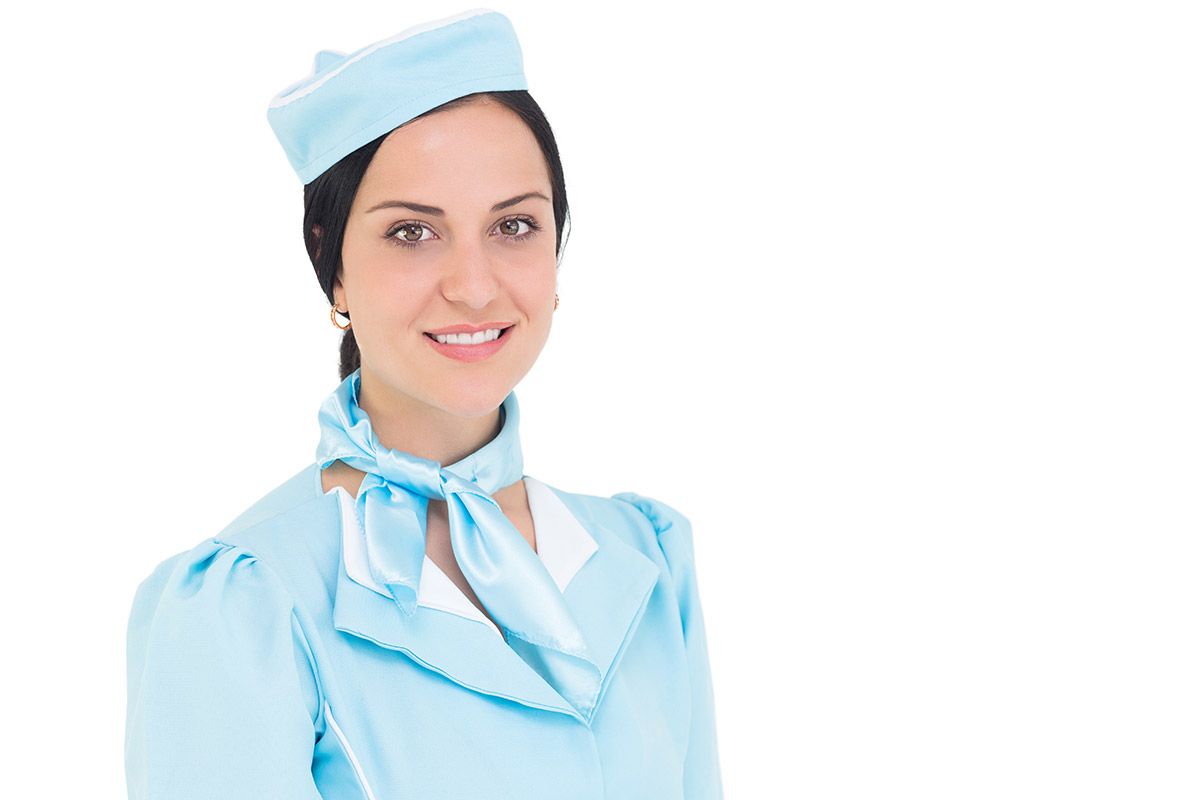 Pretty air hostess smiling at camera on white background Pretty air hostess smiling at camera on white background